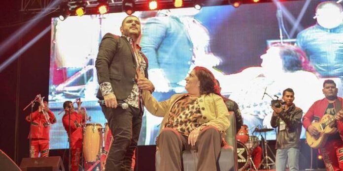 canta a una mujer del público en el escenario.