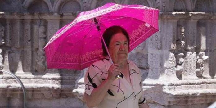 Mujer se protege con una sombrilla Mujer se protege con una sombrilla