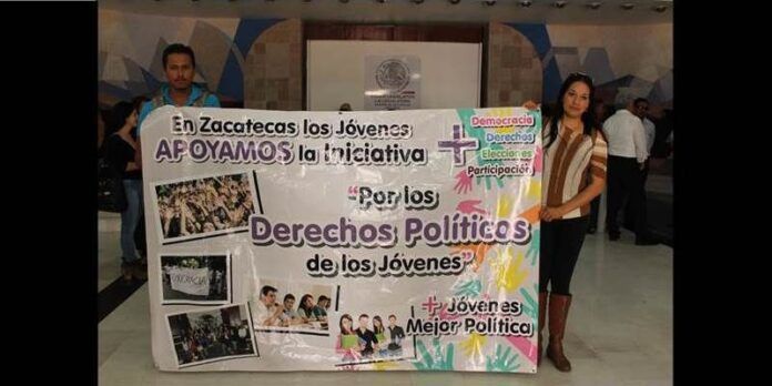 Jóvenes manifestantes con pancarta Jóvenes manifestantes con pancarta