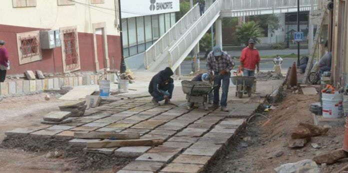 Trabajadores colocan el piso Trabajadores colocan el piso