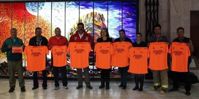 Organizadores posan con playeras alusivas Organizadores posan con playeras alusivas