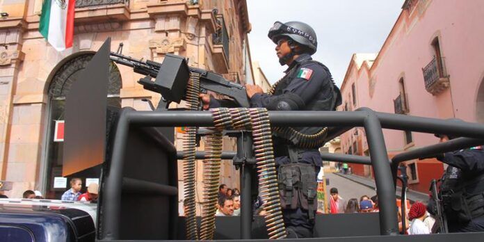 Policía mostrando una de las armas de la corporación Policía mostrando una de las armas de la corporación
