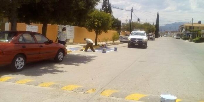 Trabajadores pintan señalamientos viales