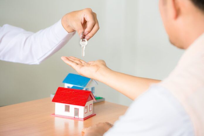 Real estate Sales manager giving keys to customer after signing