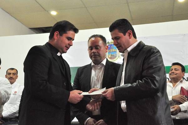 El párroco Lisandro Rivas recibió un cheque para escuela