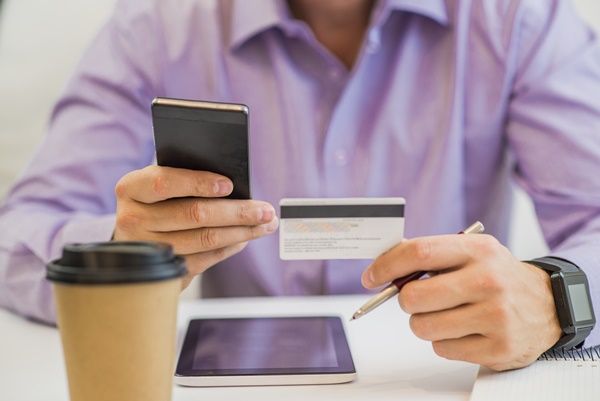 guy hand holding credit card, enjoying internet online shopping